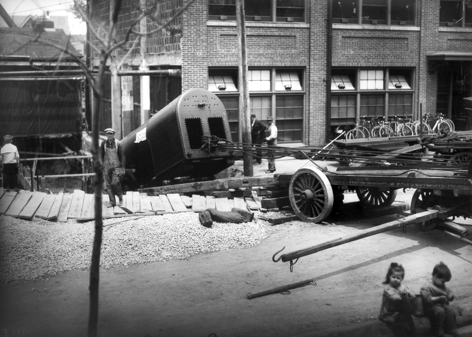 A large metal chamber is winched down a ramp