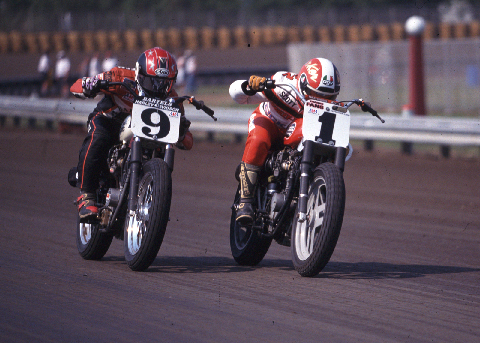 Two racers battle for the lead on a round track 