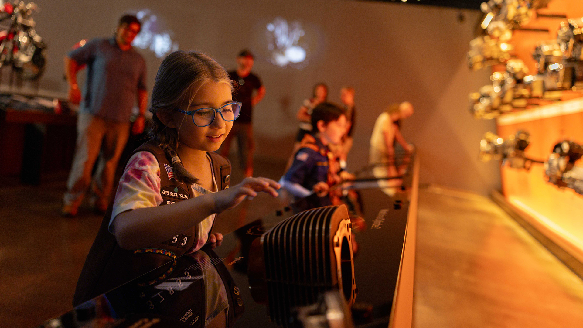 Child interacting with hands-on engine display in museum exhibit