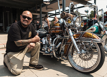 man kneeling next to motorcycle