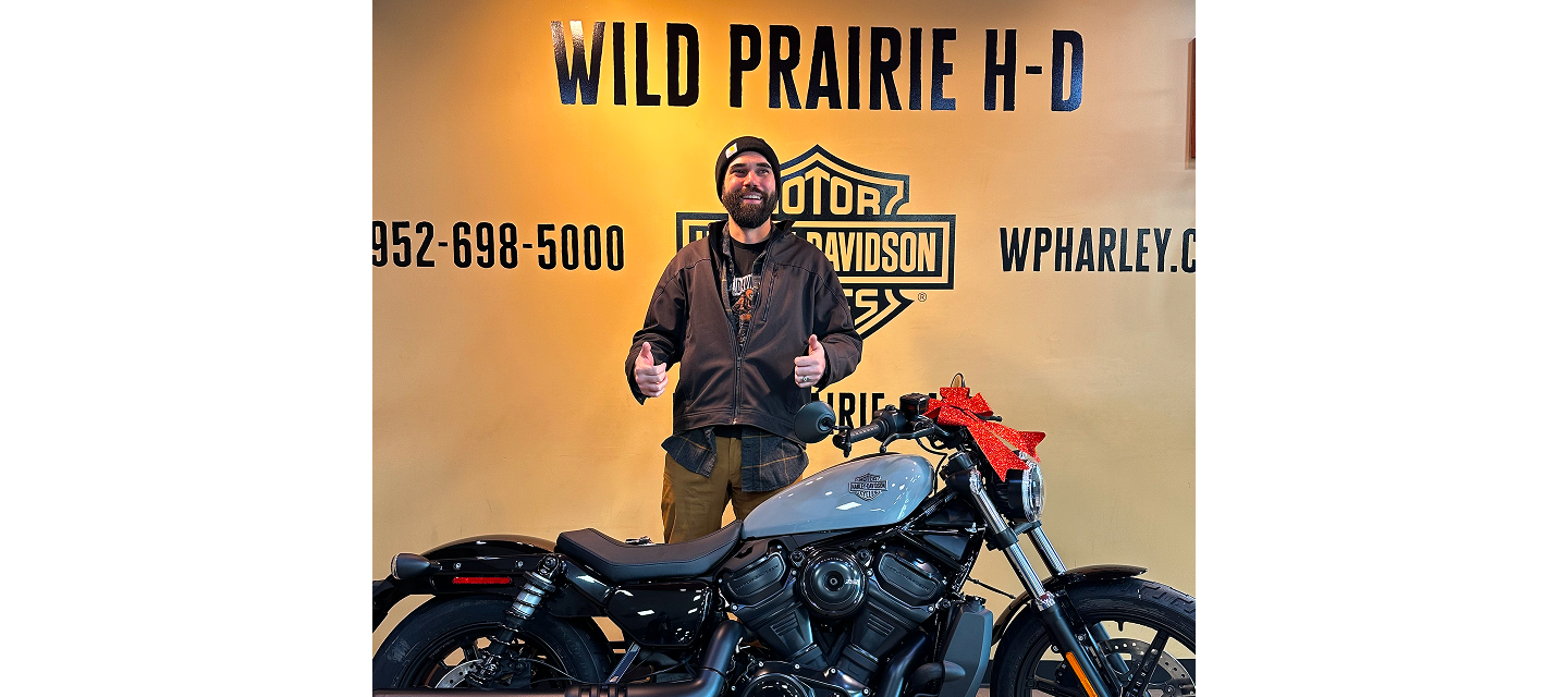 Silver Tier winner Alex Soberg gives two thumbs up standing next to the 2025 Nightster he won in the Let’s Ride Challenge