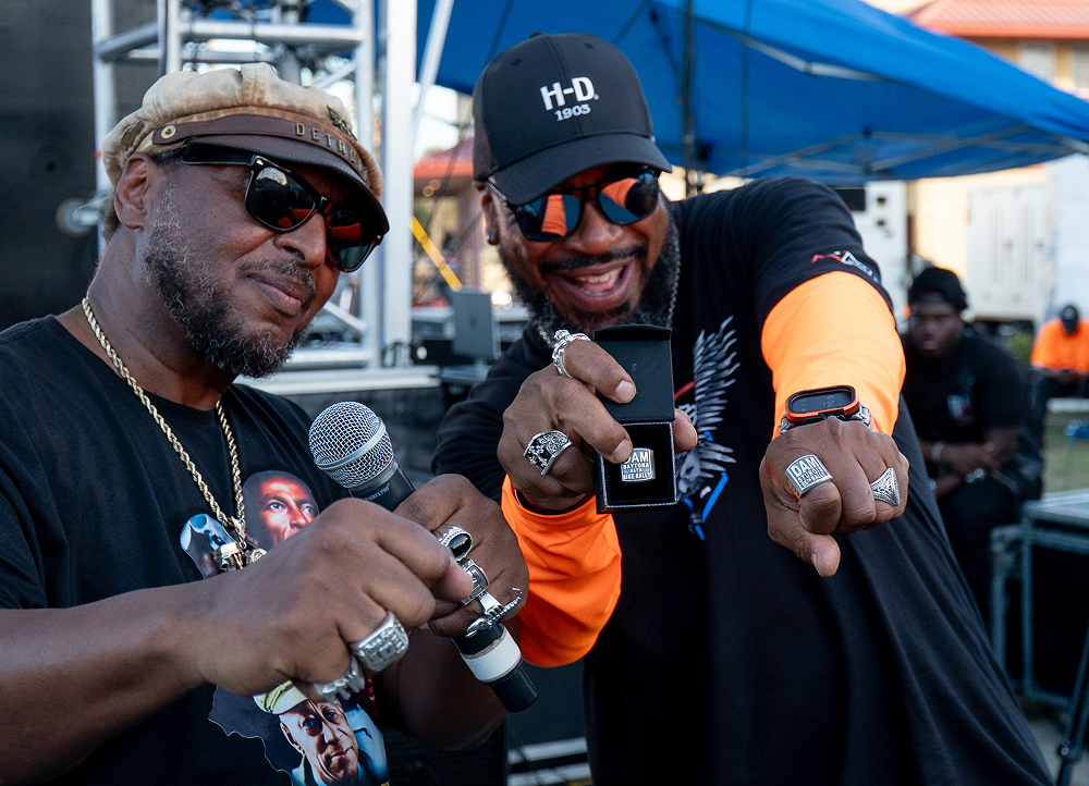 Randy “Detroit” Hayward and a bike builder gesture toward the camera during the DAM ring award ceremony