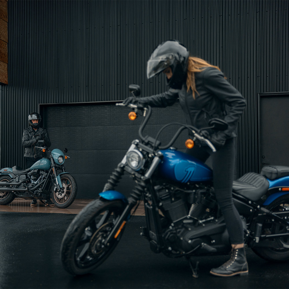Woman stands on motorcycle