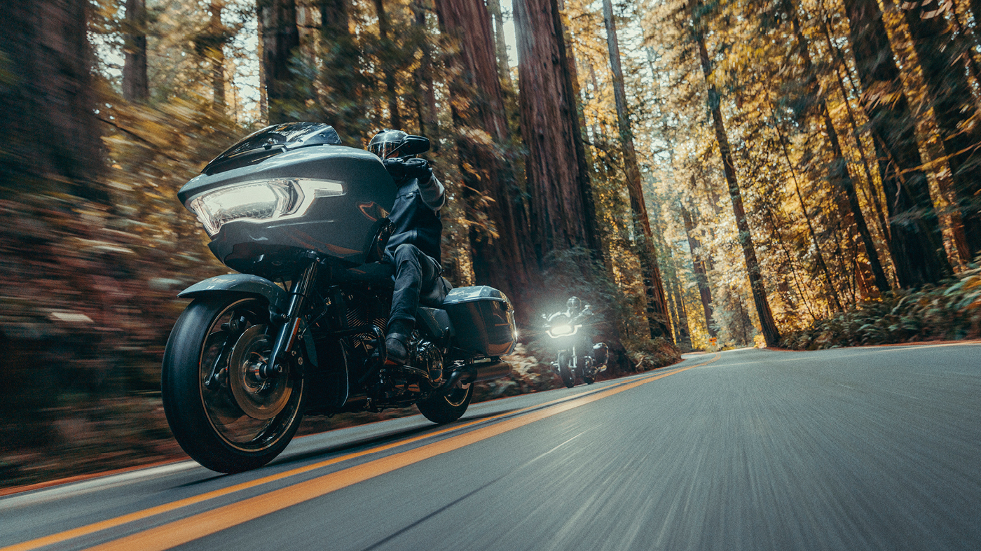 Motorcyclist rides Road Glide on tree lined road
