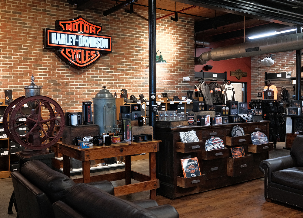 Harley-Davidson retail area with branded merchandise, vintage decor, and logo wall inside dealership lounge
