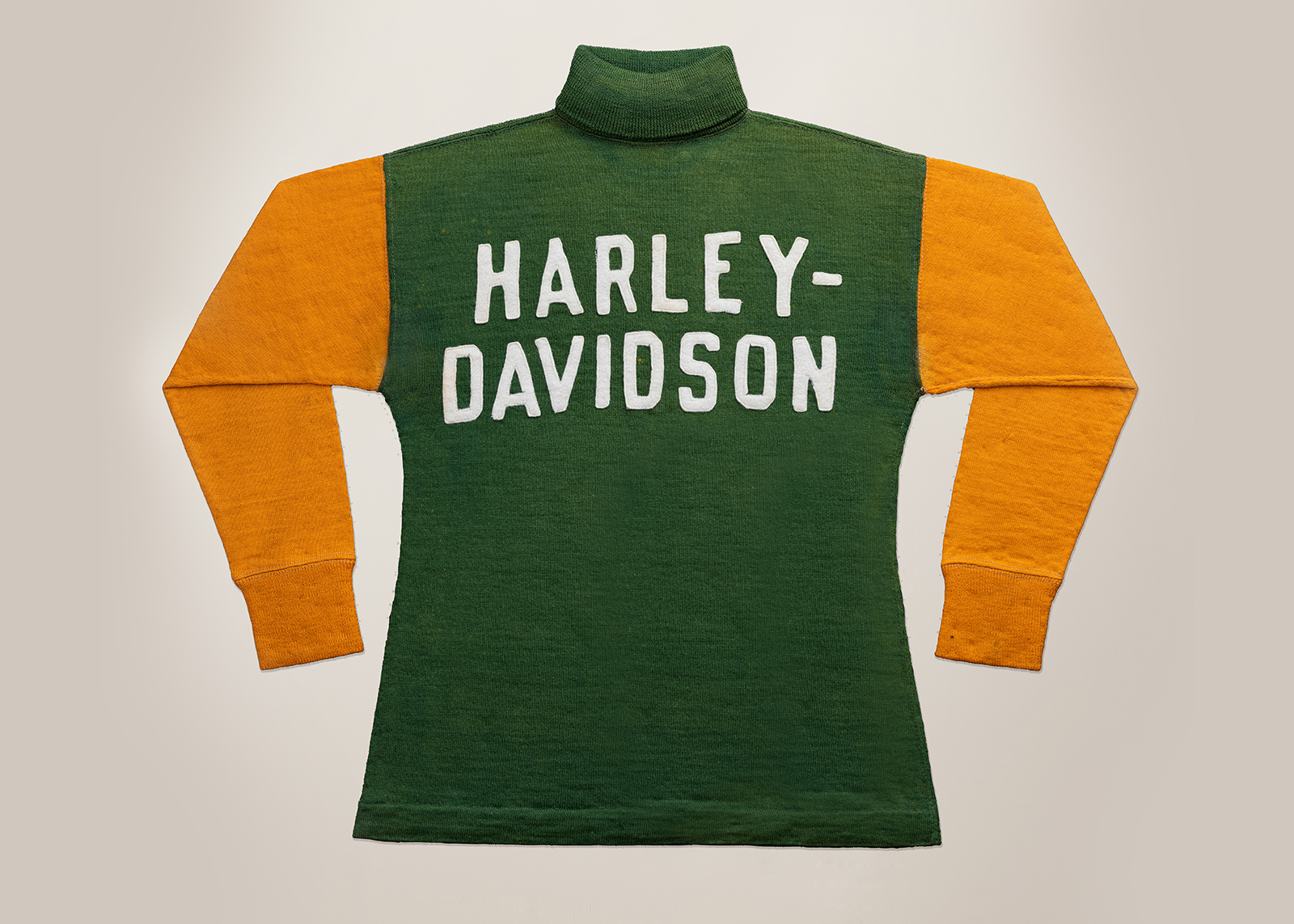 A yellow and green vintage h-d sweater layed down