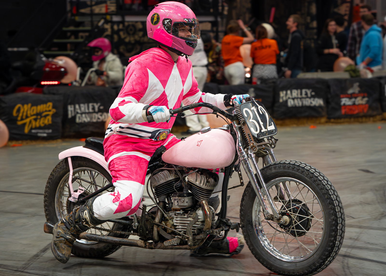A man dressed in pink matches his race bike on the track