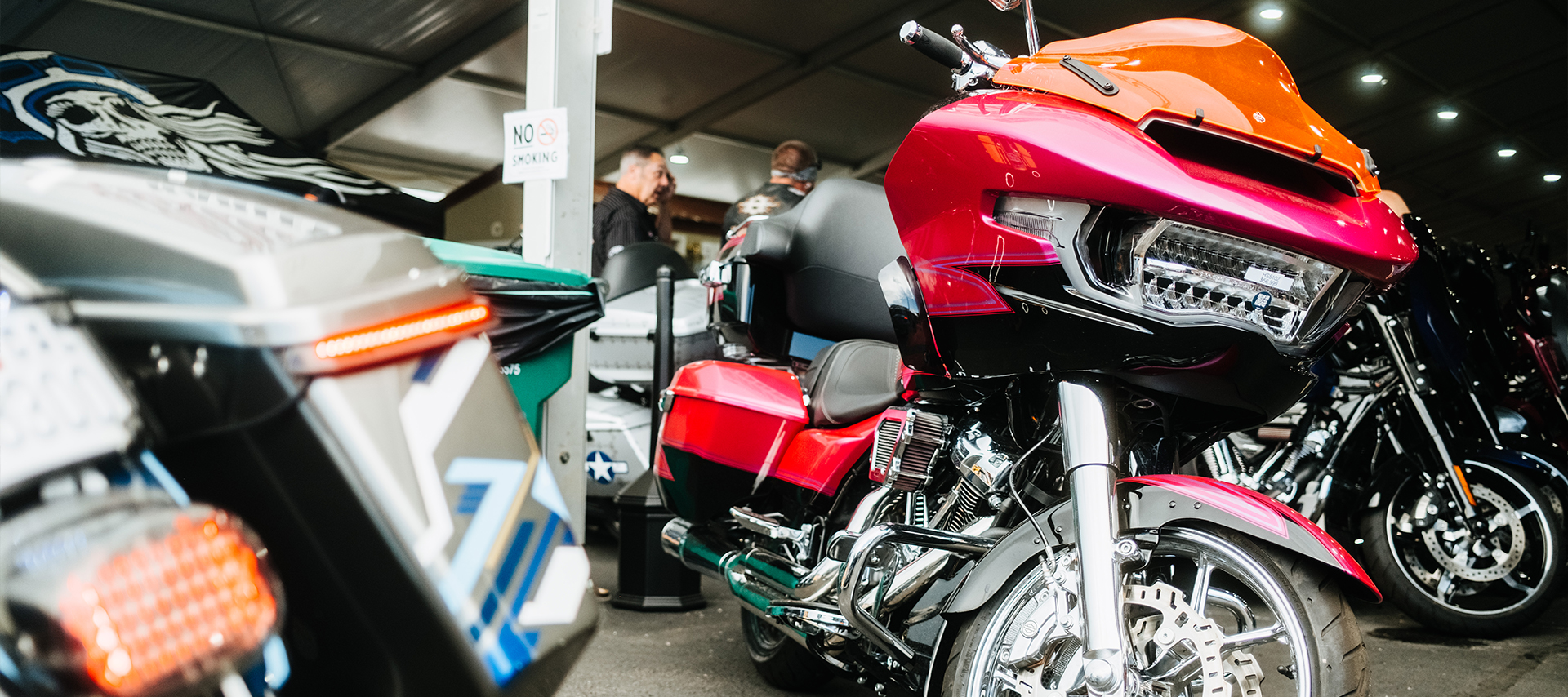 Custom red Harley-Davidson with an orange windshield on display at Black Hills Harley-Davidson alongside other motorcycles.