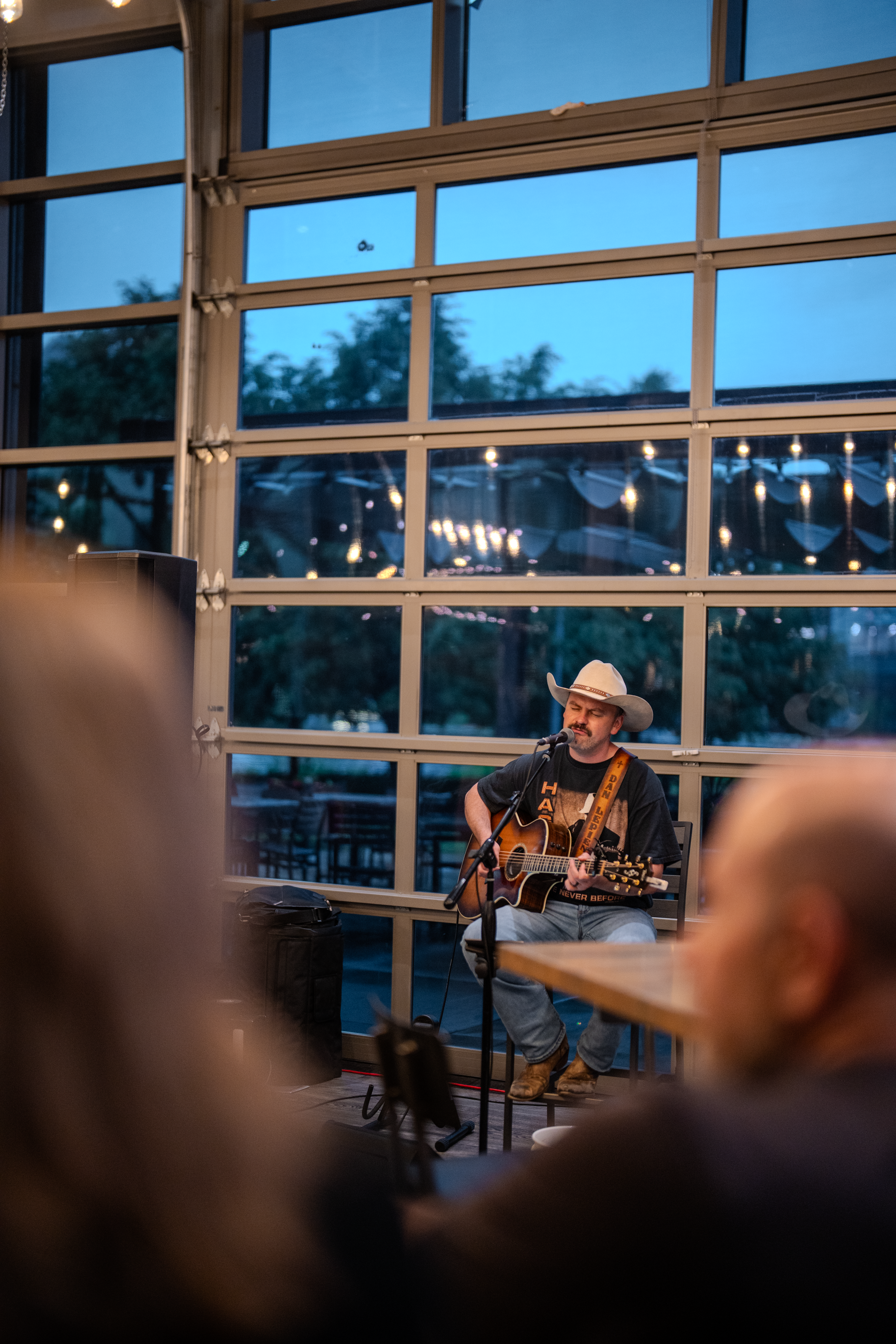 Musician performing acoustic set inside Harley-Davidson themed restaurant