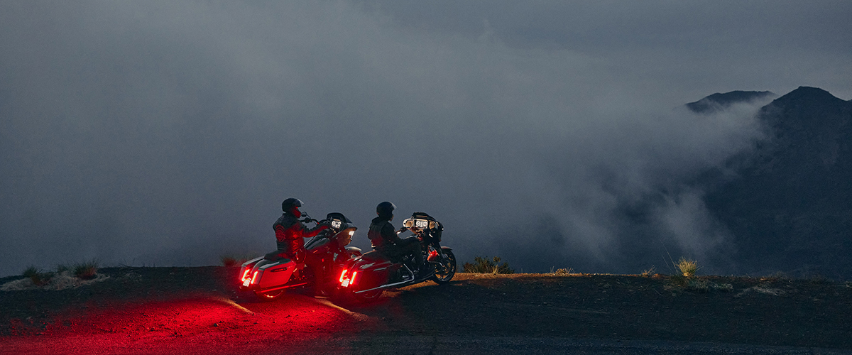 Two bikers overlook mountains
