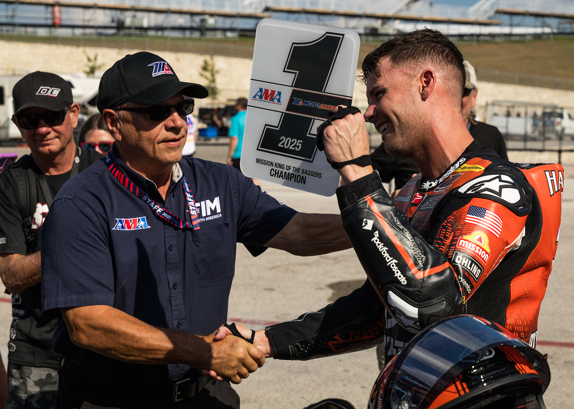 Kyle Wyman shakes the hand of a Moto America official after being handed the winning #1 champion plate.