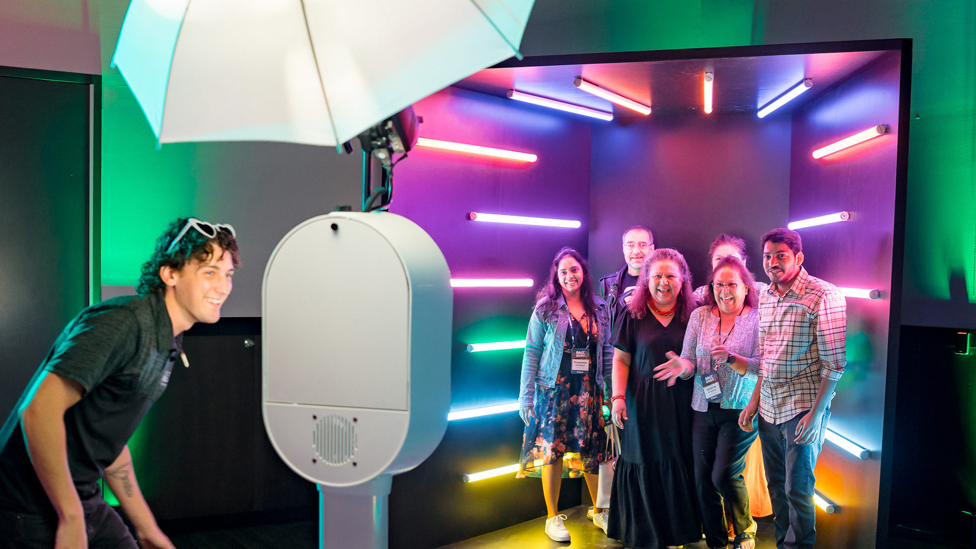Group posing in photo booth with colorful light backdrop