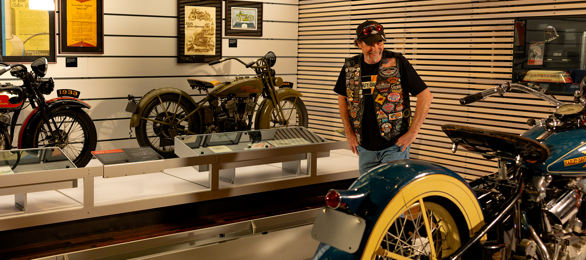Visitor examining vintage Harley-Davidson motorcycles in museum display