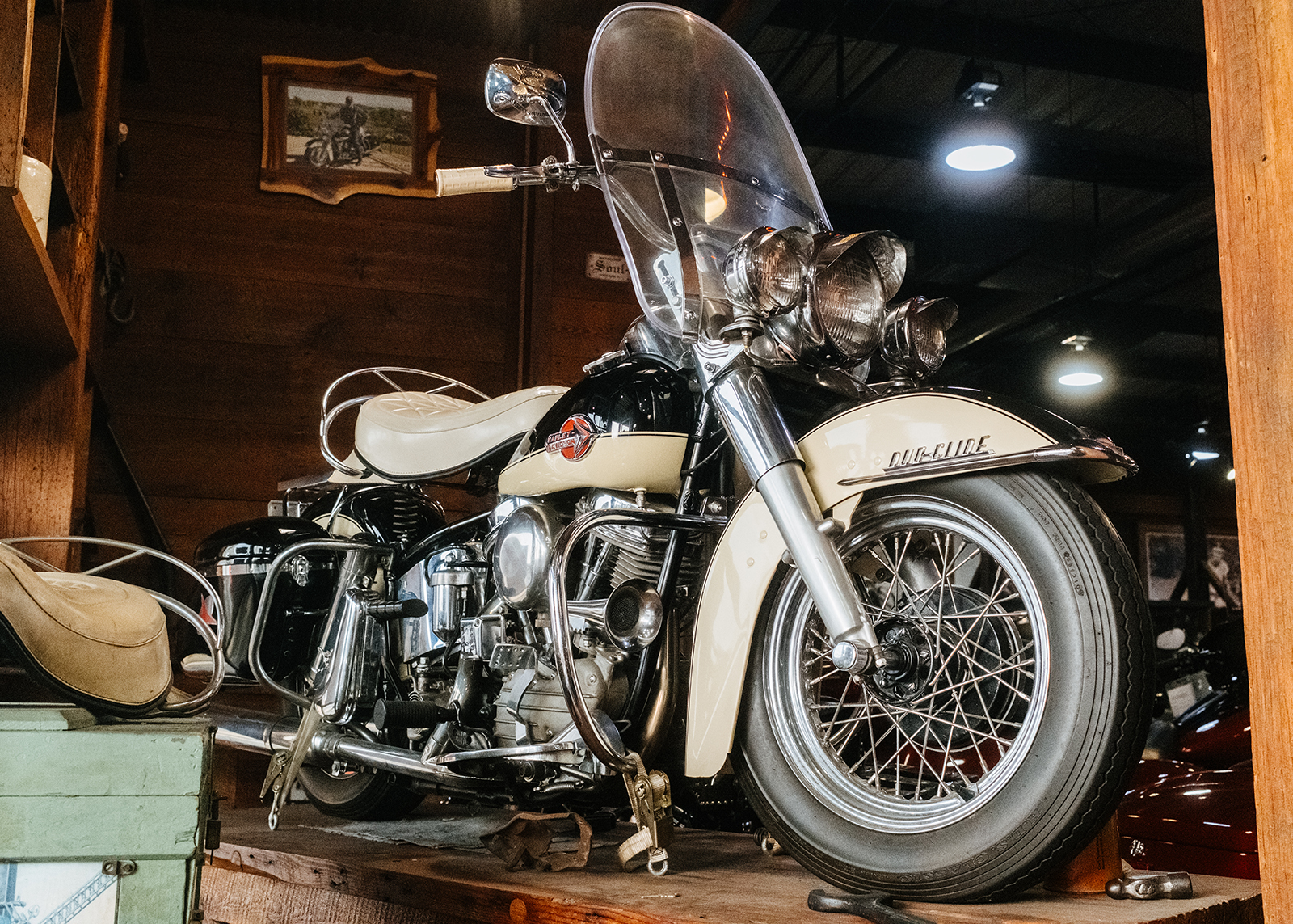 Vintage Duo Glide Harley-Davidson on display on a wooden platform.