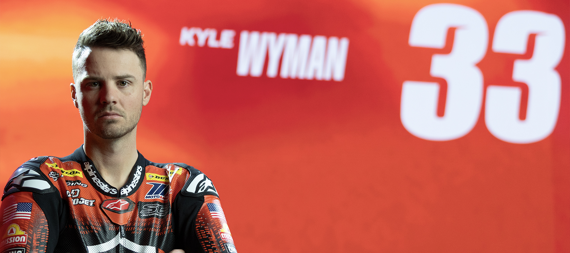 Kyle Wyman stands before his number, 33