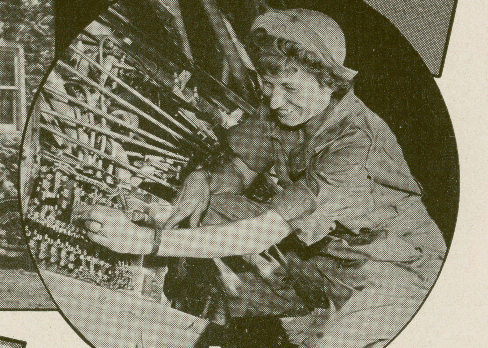 A woman smiles while working on an assembly line