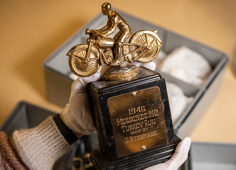 Gold motorcycle trophy mounted on a black base with engraved text saying “1946 Milwaukee MC Turkey Run Won By G-Stenmark”