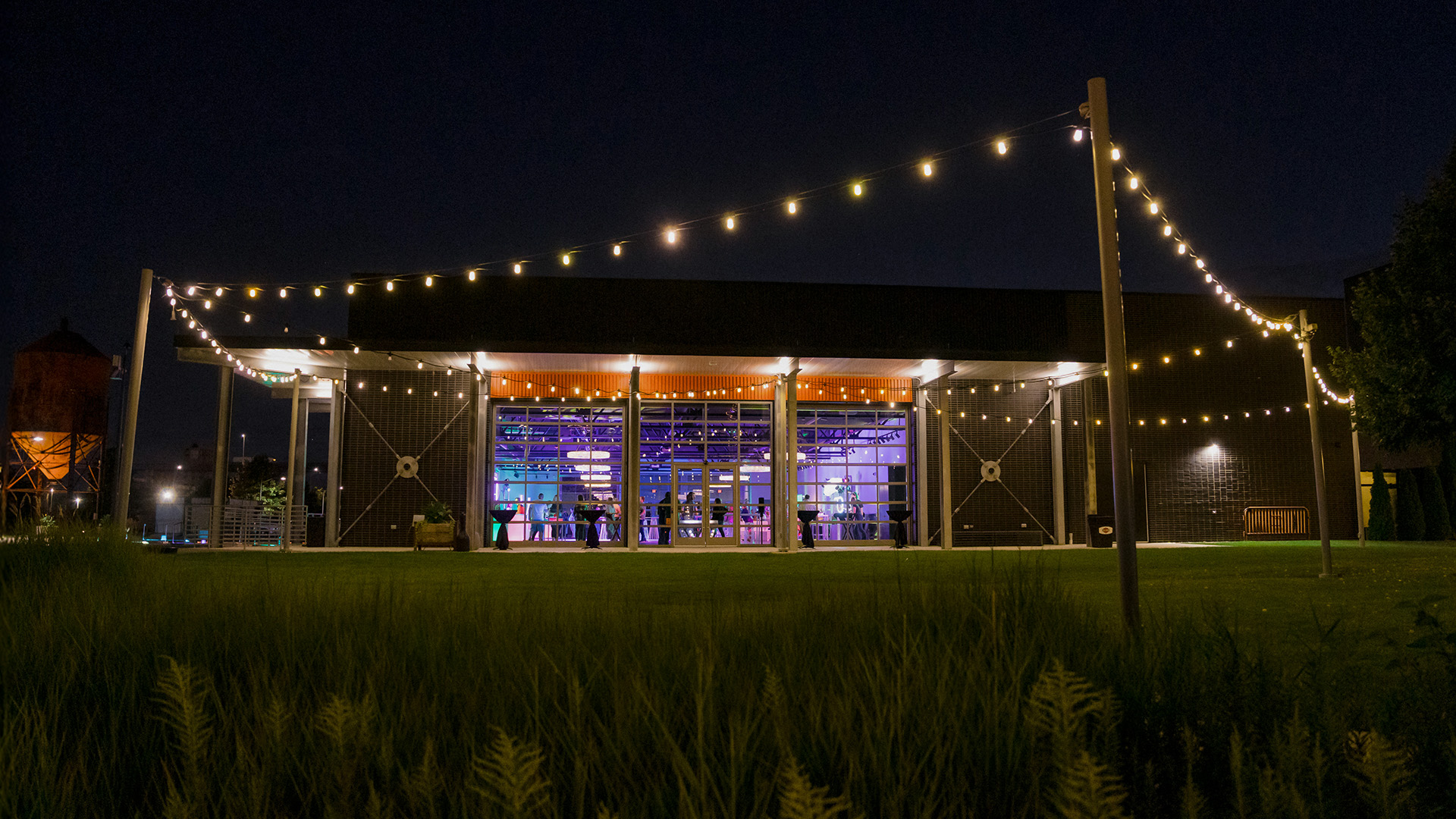 Event pavilion illuminated with string lights at Harley-Davidson campus