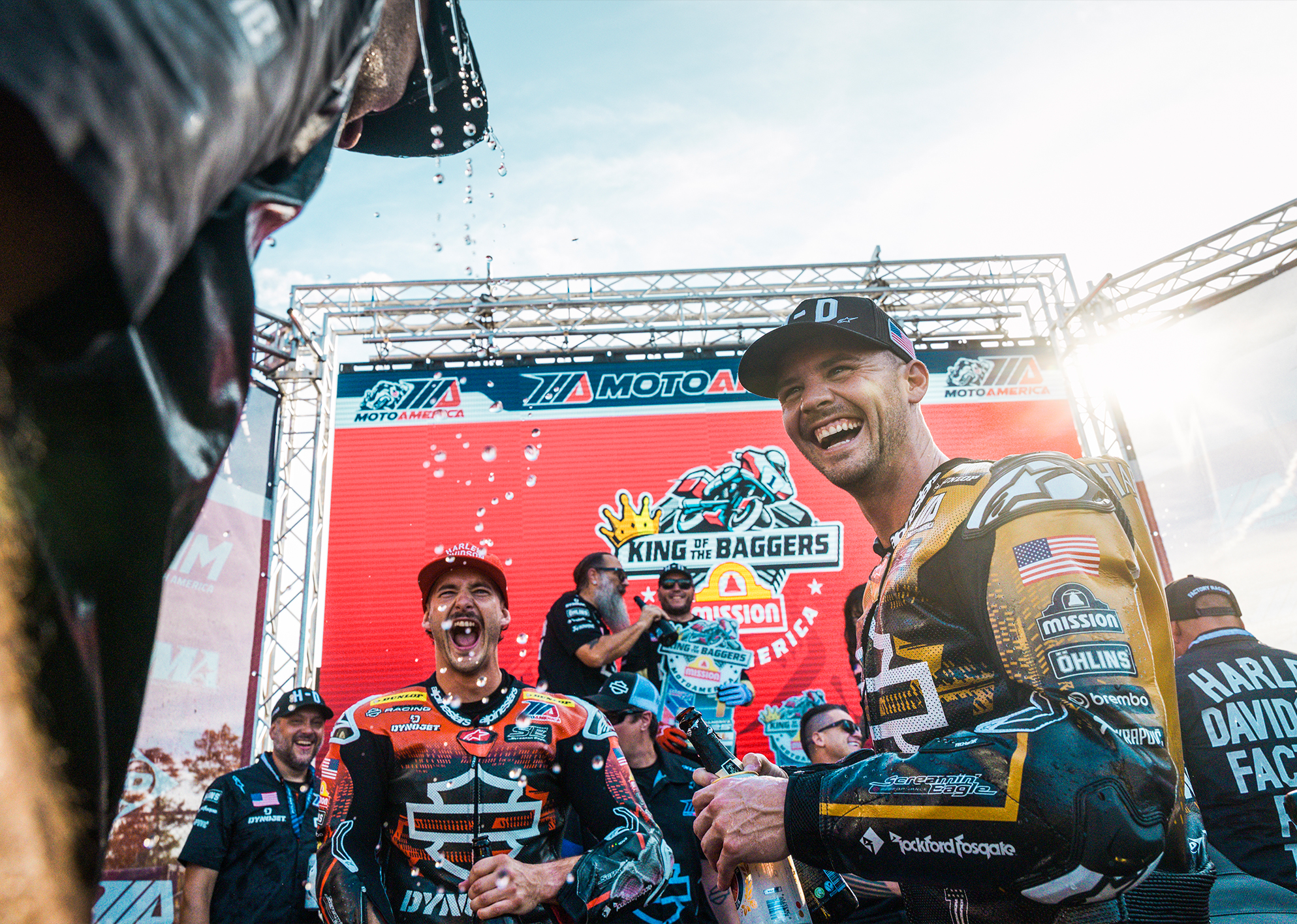 Kyle Wyman and James Rispoli laugh after dousing their teammate with champagne after the final race of the King of the Baggers season.