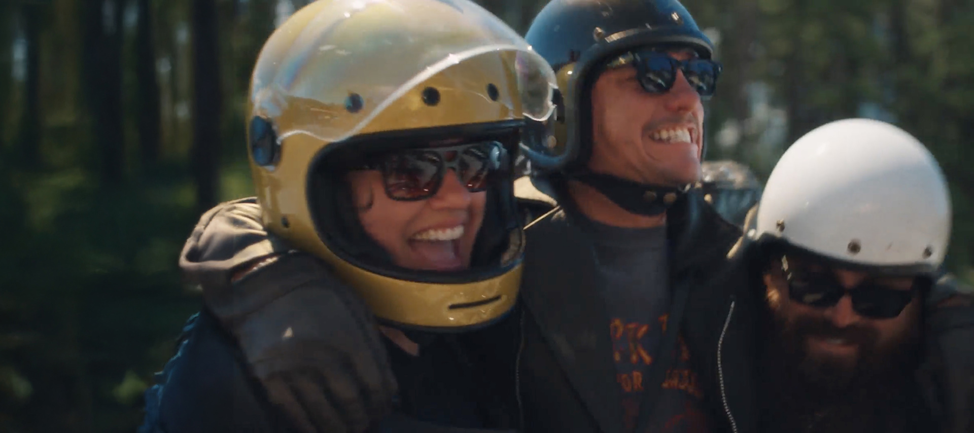 3 motociclistas de capacete rindo