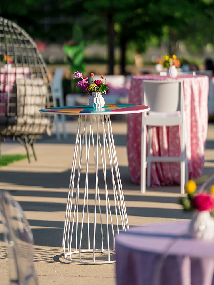 Cocktail tables with floral centerpieces on outdoor event patio